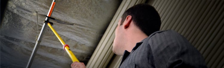 Worker applying a pipe label with a pipe marking applicator.