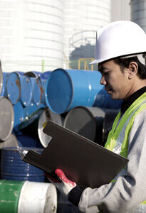 Worker in PPE performing a chemical risk assessment