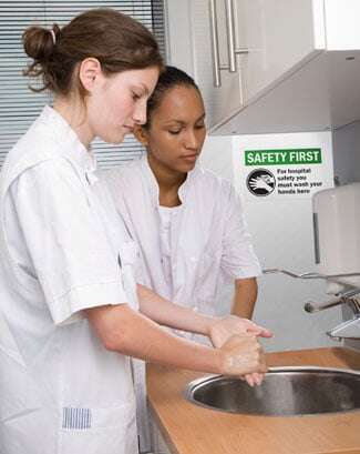 Two women wash their hands before returning to work.